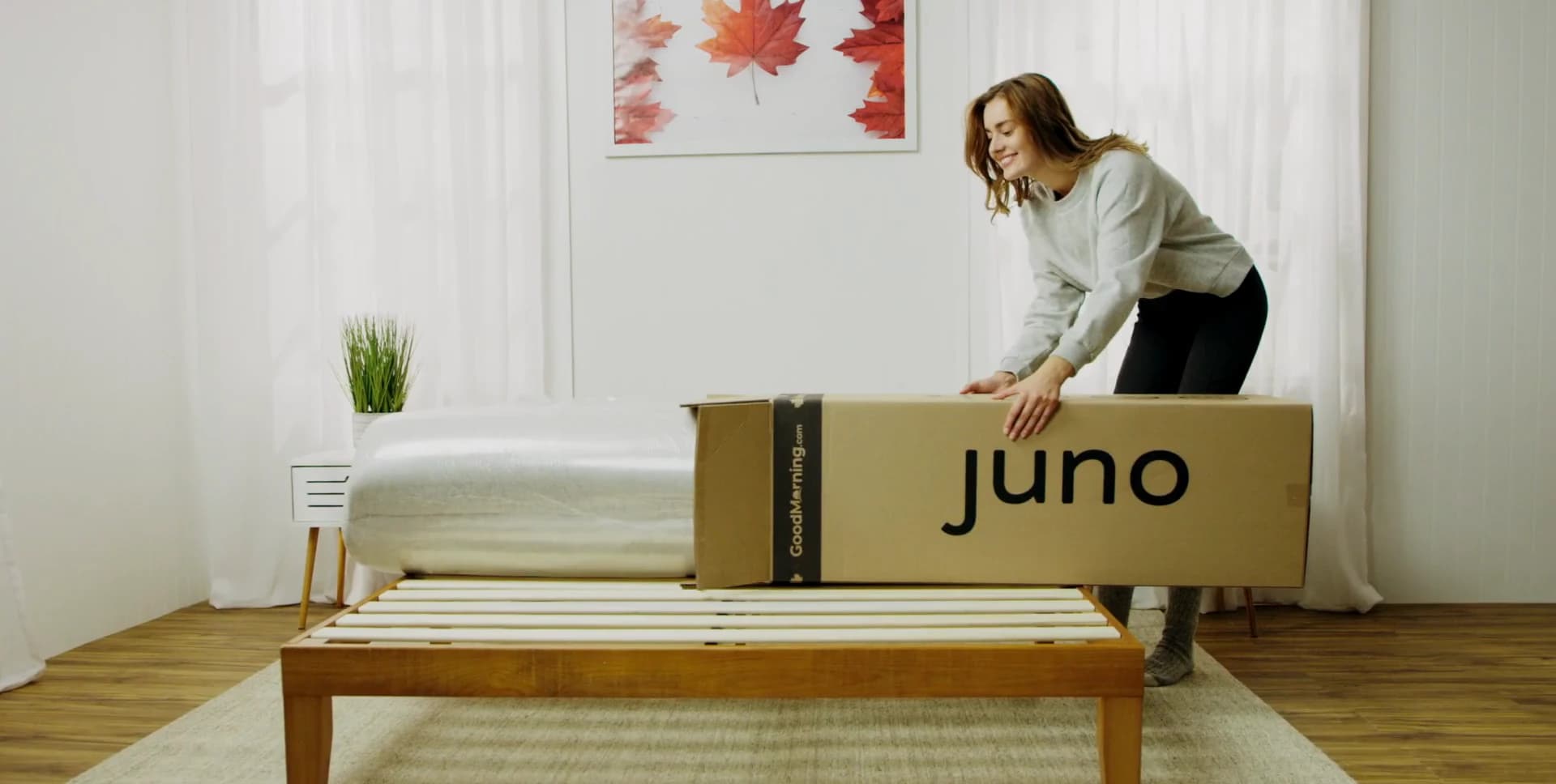 A genuine Juno launch frame with the boxed mattress presented in the campaign bedroom set.