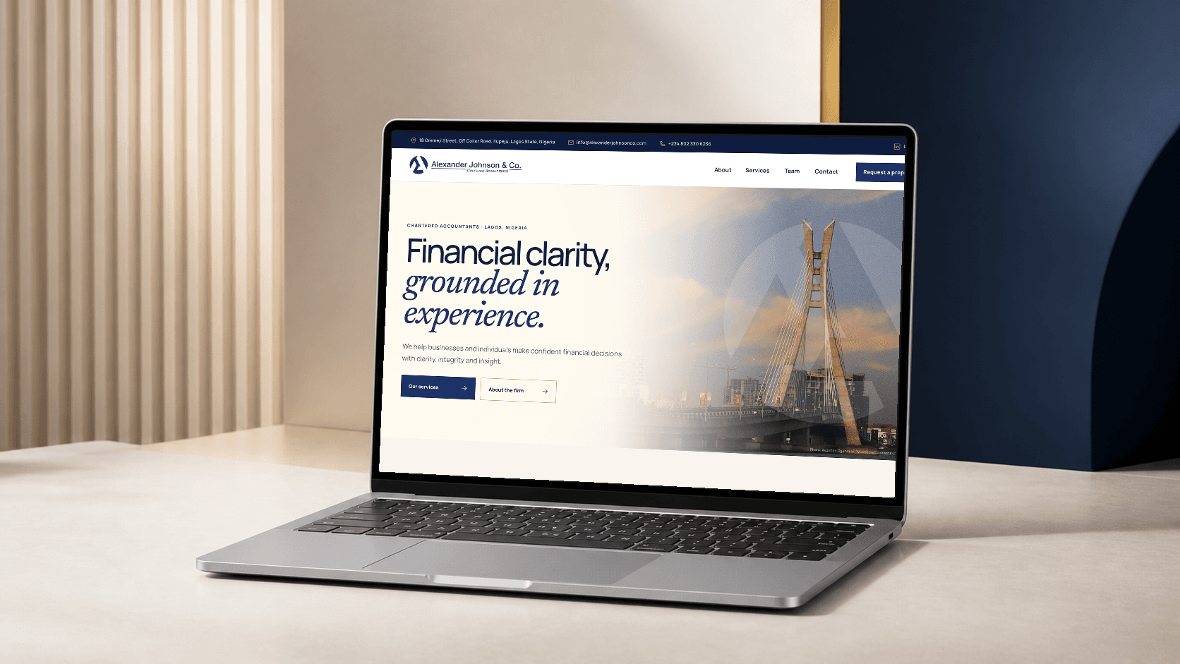 The completed Alexander Johnson and Co website presented on a laptop in its navy, cream and gold visual world.