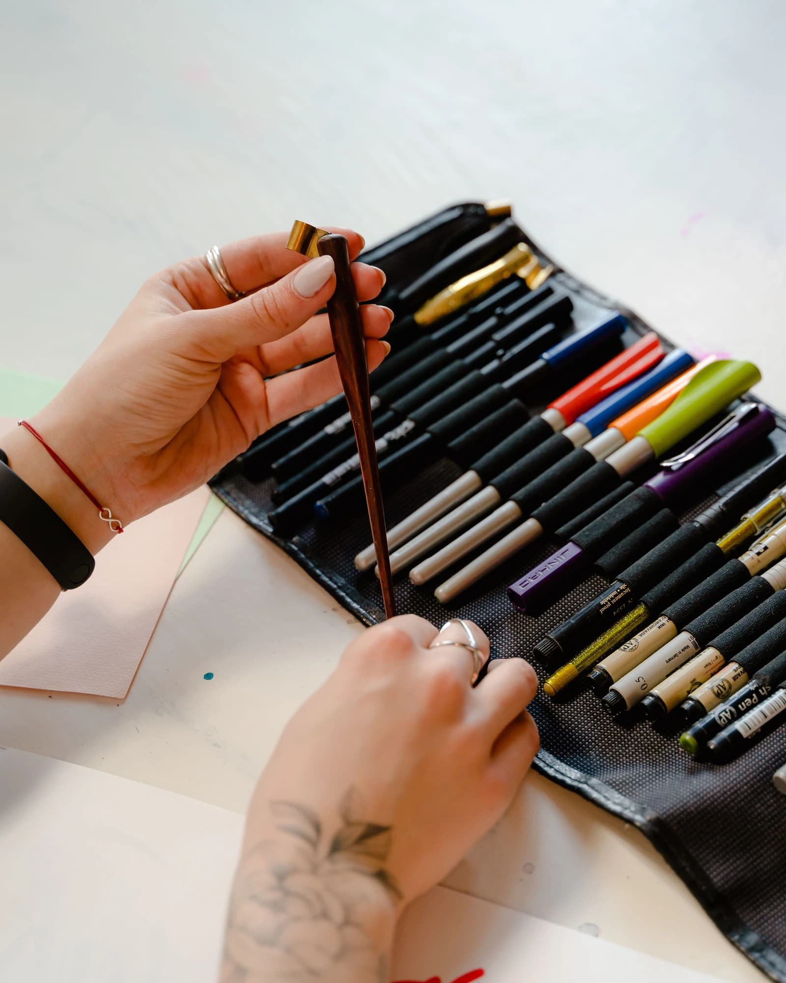 Hands selecting drawing tools during a practical creative planning session.