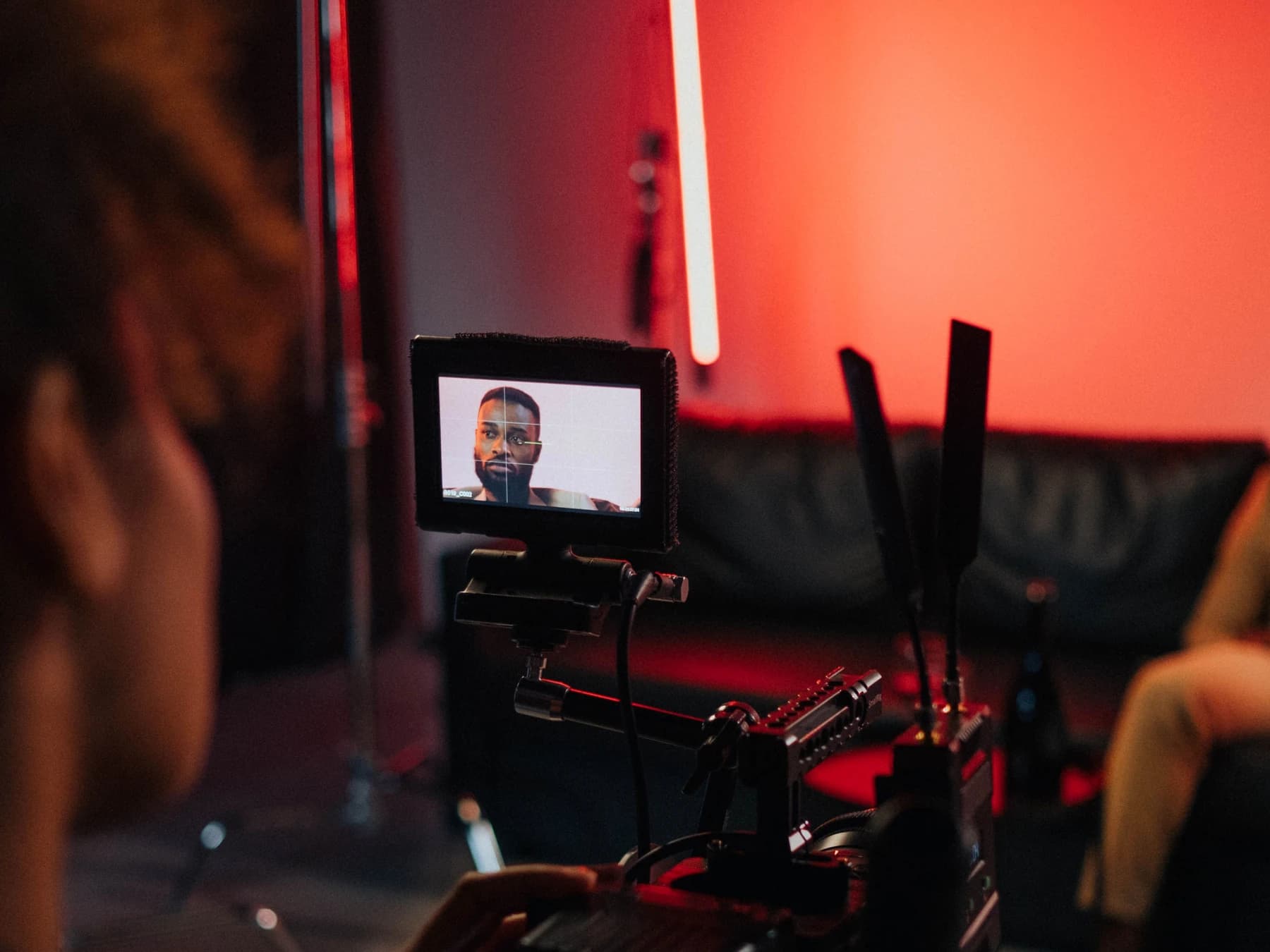 A camera operator framing a subject during a studio video production.