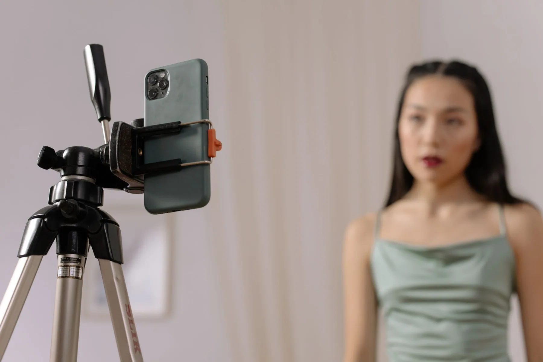 A content creator recording a social video with a smartphone on a tripod.