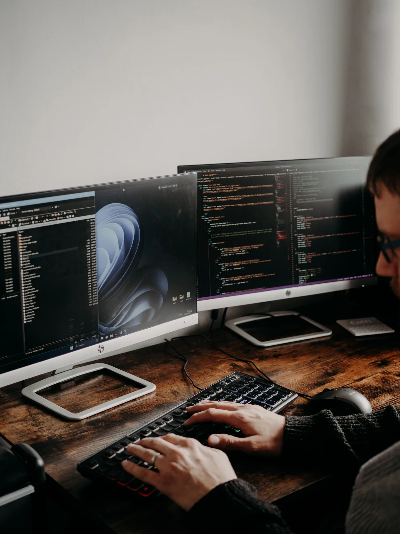 A web developer working across multiple code and browser screens.